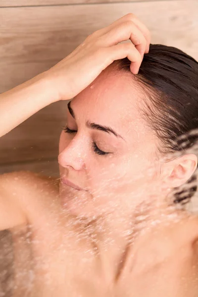 Joven mujer hermosa bajo la ducha en el baño . — Foto de Stock