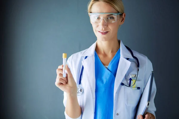 Vrouwelijke medische of onderzoekswetenschapper of arts die gebruik maakt van een reageerbuis met heldere oplossing in een laboratorium of laboratorium. — Stockfoto