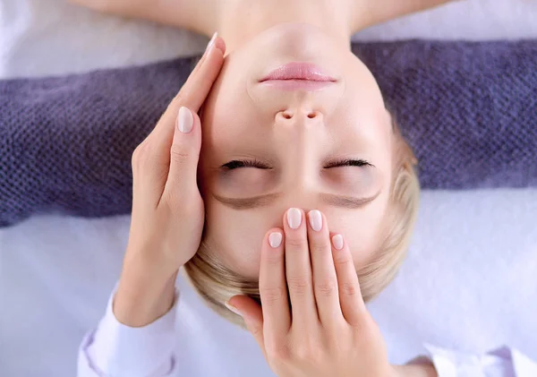 Jovem deitada em uma mesa de massagem, relaxando com os olhos fechados. Mulher. Salão de Spa — Fotografia de Stock