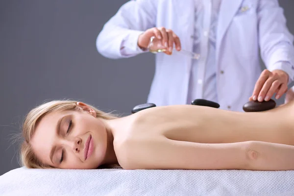 Jovem deitada em uma mesa de massagem, relaxando com os olhos fechados. Mulher. Salão de Spa — Fotografia de Stock