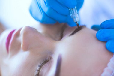 Kaşlar için kalıcı makyaj. Güzellik salonunda kalın kaşlı güzel bir kadın.