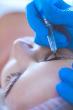 Kaşlar için kalıcı makyaj. Güzellik salonunda kalın kaşlı güzel bir kadın.