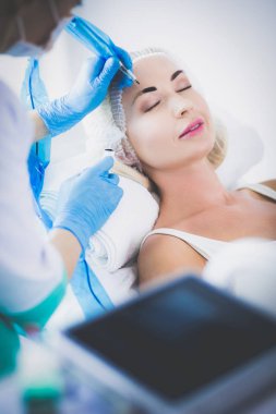 Kaşlar için kalıcı makyaj. Güzellik salonunda kalın kaşlı güzel bir kadın.