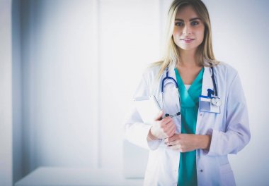 Tıp ofisinde kollarını kavuşturmuş kendine güvenen kadın doktorların portresi.