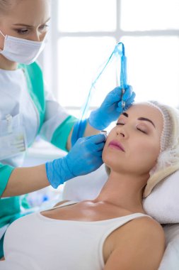 Kaşlar için kalıcı makyaj. Güzellik salonunda kalın kaşlı güzel bir kadın.