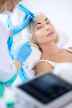 Kaşlar için kalıcı makyaj. Güzellik salonunda kalın kaşlı güzel bir kadın.