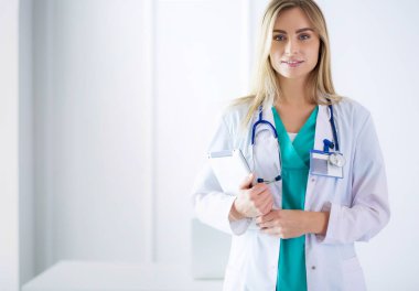 Tıp ofisinde kollarını kavuşturmuş kendine güvenen kadın doktorların portresi.