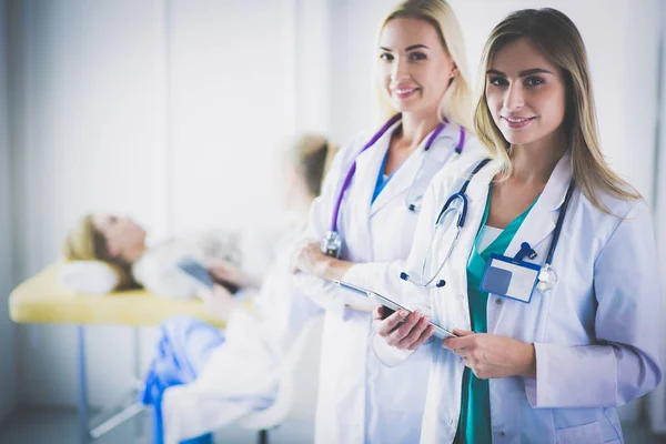 Портрет впевнених жінок-лікарів, що стоять з обіймами, схрещеними в медичному кабінеті — стокове фото