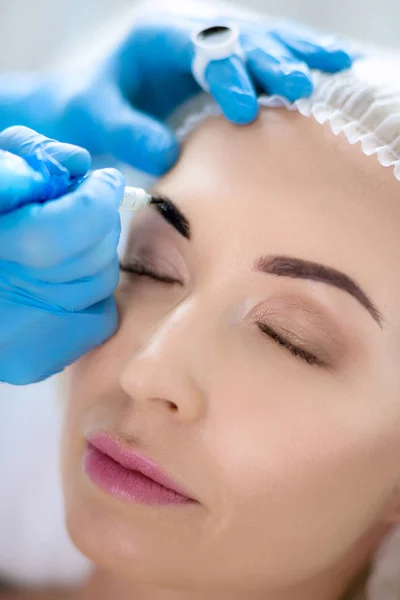 Permanent makeup for eyebrows. Closeup of beautiful woman with thick brows in beauty salon — Stock Photo, Image