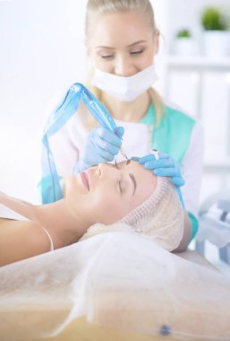 Kaşlar için kalıcı makyaj. Güzellik salonunda kalın kaşlı güzel bir kadın.