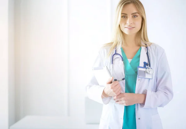 Portret pewnej siebie lekarki stojącej z rękami skrzyżowanymi w gabinecie lekarskim — Zdjęcie stockowe