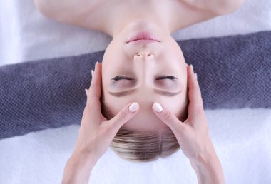 Masaj masasında uzanmış gözleri kapalı rahatlayan genç bir kadın. - Kadın. Spa salonu