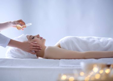 Masaj masasında uzanmış gözleri kapalı rahatlayan genç bir kadın. - Kadın. Spa salonu