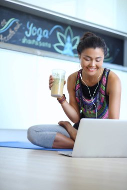 Aydınlık salonda dizüstü bilgisayar kullanan sportif gülümseyen kadın. Kadın. Yaşam tarzı