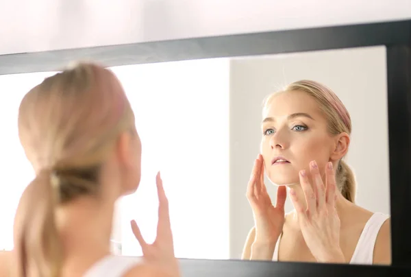 Gezicht van jonge mooie gezonde vrouw en reflectie in de spiegel — Stockfoto