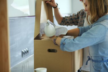 Genç bir çift yeni evde büyük karton kutu taşıyan. Ev taşıma. Genç Çift