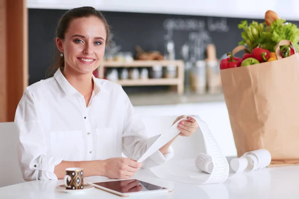 Young woman planning expenses and paying bills on her kitchen. — Stock Photo, Image