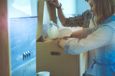 Genç bir çift yeni evde büyük karton kutu taşıyan. Ev taşıma. Genç Çift