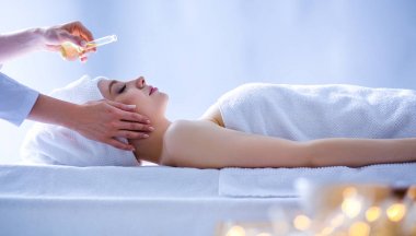 Masaj masasında uzanmış gözleri kapalı rahatlayan genç bir kadın. - Kadın. Spa salonu