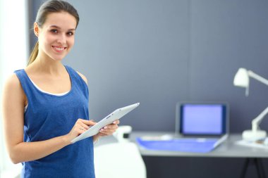 Ev ofisinde tablet üzerinde çalışan çekici bir kadın.