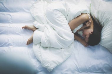 Güzel bir kadın yatağında uzanıyor.
