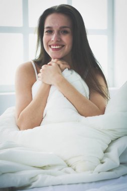 Yatağında evde oturan güzel kadın