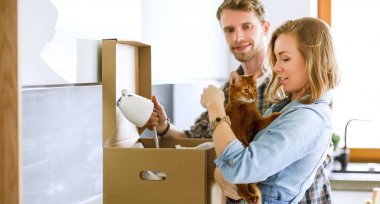 Genç bir çift yeni evde büyük karton kutu taşıyan. Ev taşıma. Genç Çift