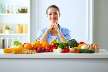 Mutfakta masada oturan genç bir kadın. .