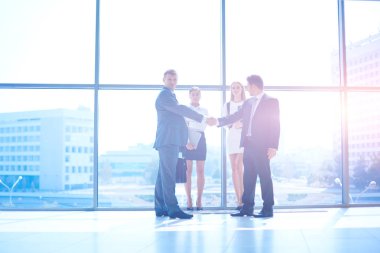 İki başarılı iş adamının el sıkışırken tam boy görüntüsü.