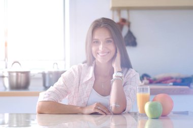 Mutfakta masada oturan genç bir kadın. Genç kadın.