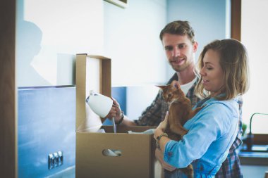 Genç bir çift yeni evde büyük karton kutu taşıyan. Ev taşıma. Genç Çift