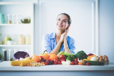 Mutfakta masada oturan genç bir kadın. .