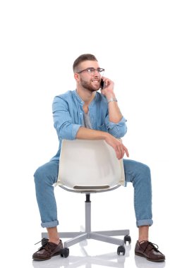 Sandalyede oturan ve cep telefonuyla genç adam. Startupper. Genç girişimci.