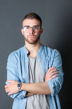 Mutlu bir casual adam ayakta karanlık bir arka plan üzerinde izole portresi. Yakışıklı erkek poz.