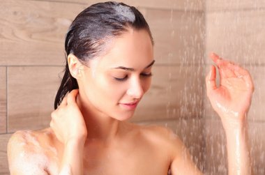 Genç beautyful kadın banyoda duş altında.