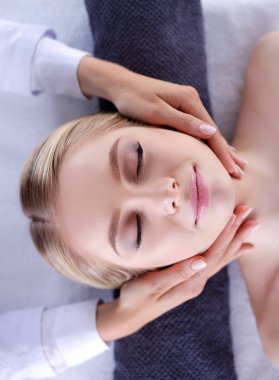 Masaj masasında uzanmış gözleri kapalı rahatlayan genç bir kadın. - Kadın. Spa salonu