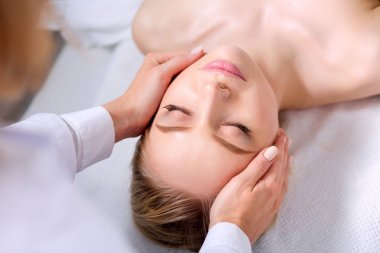 Masaj masasında uzanmış gözleri kapalı rahatlayan genç bir kadın. - Kadın. Spa salonu