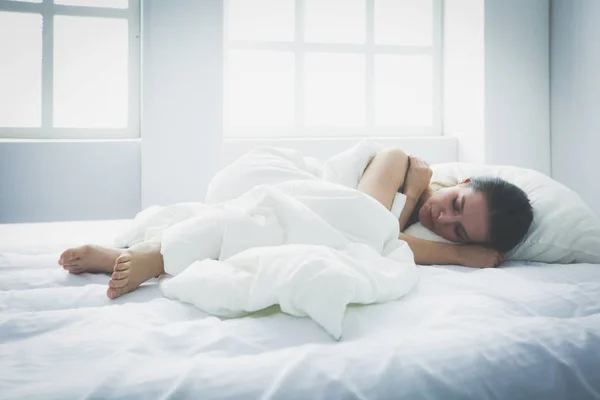 Hübsche Frau legt sich zu Hause auf ihr Bett — Stockfoto