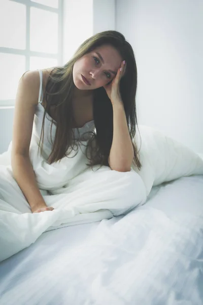 Jolie femme assise sur son lit à la maison — Photo