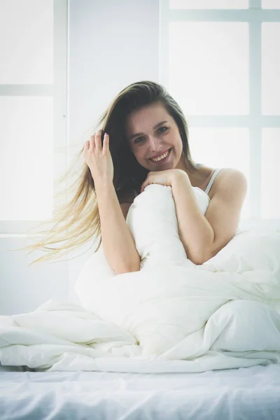 Szép nő ül ágya otthon — Stock Fotó