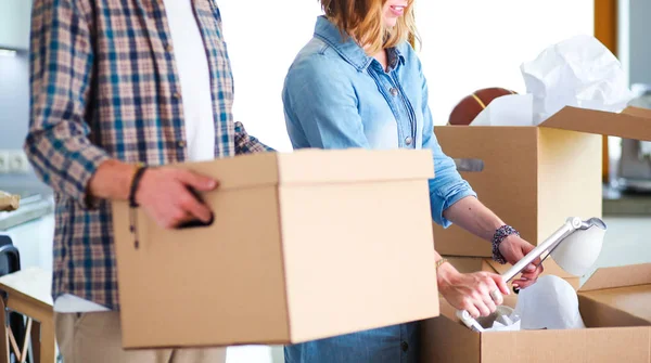 Couple unpacking cardboard boxes in their new home. Young couple. — Stock Photo, Image