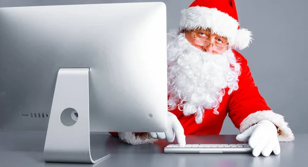 Papai Noel ler cartas de crianças e escrever respostas a eles usando laptop  . — Fotografia de Stock