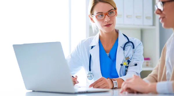 Doctor y pareja de pacientes están discutiendo algo, sentados en el escritorio. —  Fotos de Stock