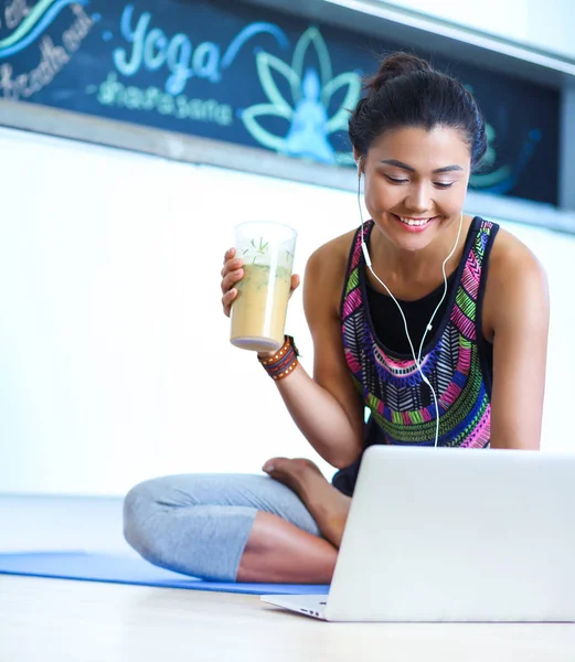 Deportiva mujer sonriente utilizando el ordenador portátil en la habitación luminosa. Una mujer. Estilo de vida — Foto de Stock