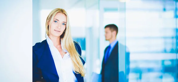 Businesswoman standing against office window talking on mobile phone . Businesswoman — Stock Photo, Image