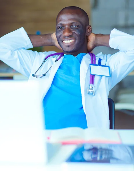 Jeune médecin africain travaillant sur ordinateur portable au bureau. Docteur. Lieu de travail — Photo