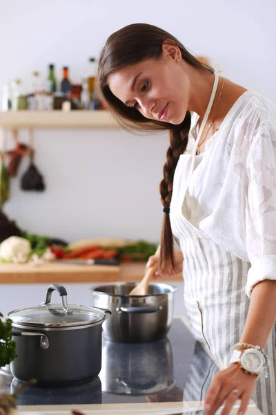 Cooking woman in kitchen with wooden spoon. Cooking woman