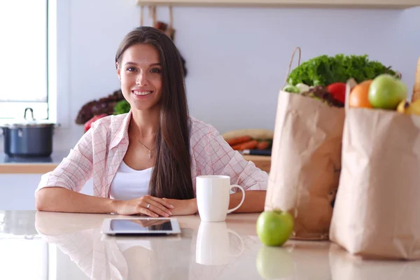 Young woman in the kitchen, using her ipad. Young woman — Stock Photo, Image