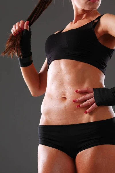 Muscular young woman standing on gray background. Muscular young woman — Stock Photo, Image