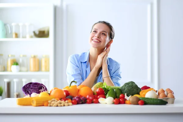 Mujer joven sentada una mesa en la cocina . — Foto de Stock